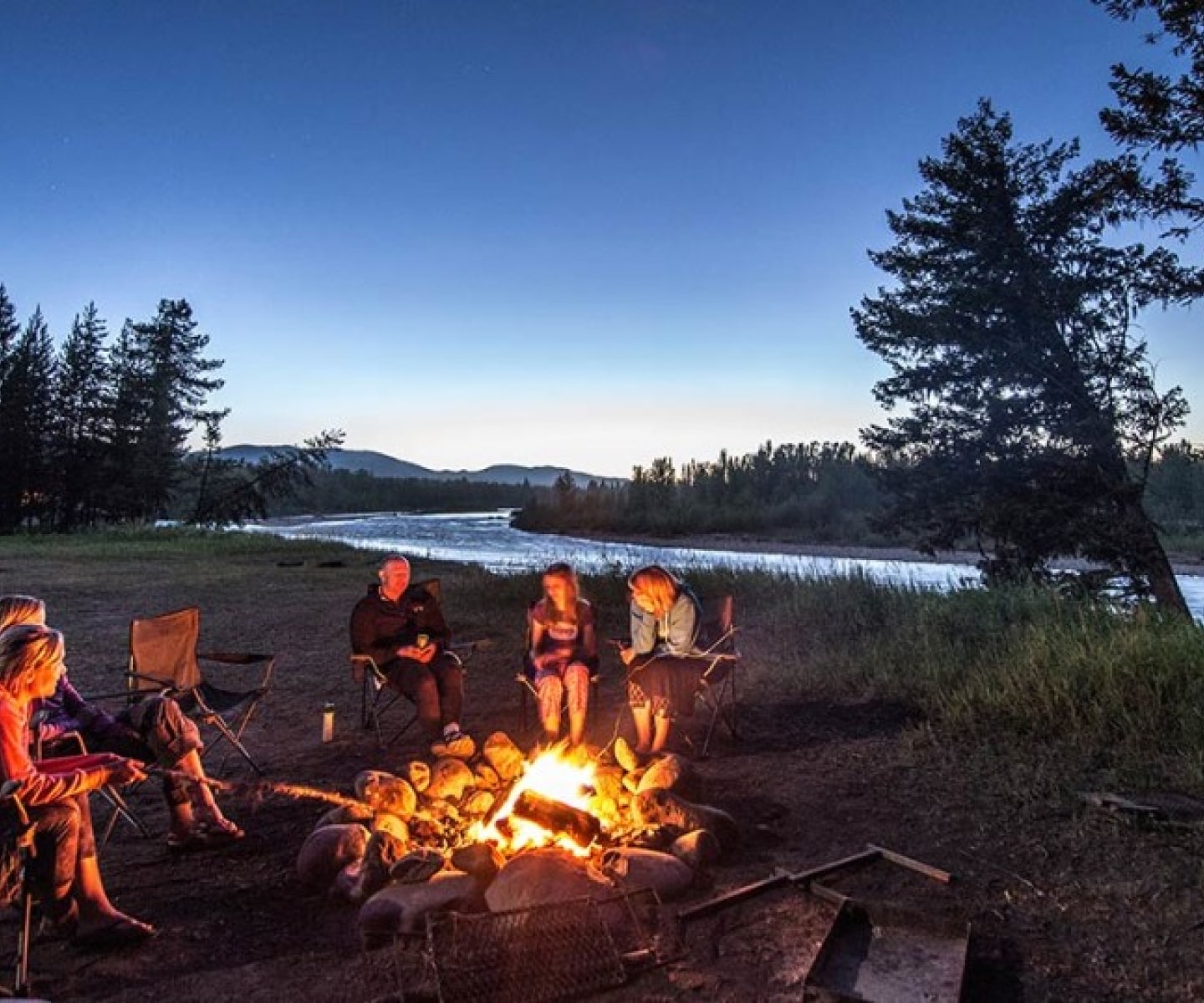 Guests enjoying a campfire on an overnight whitewater rafting trip with Wild River