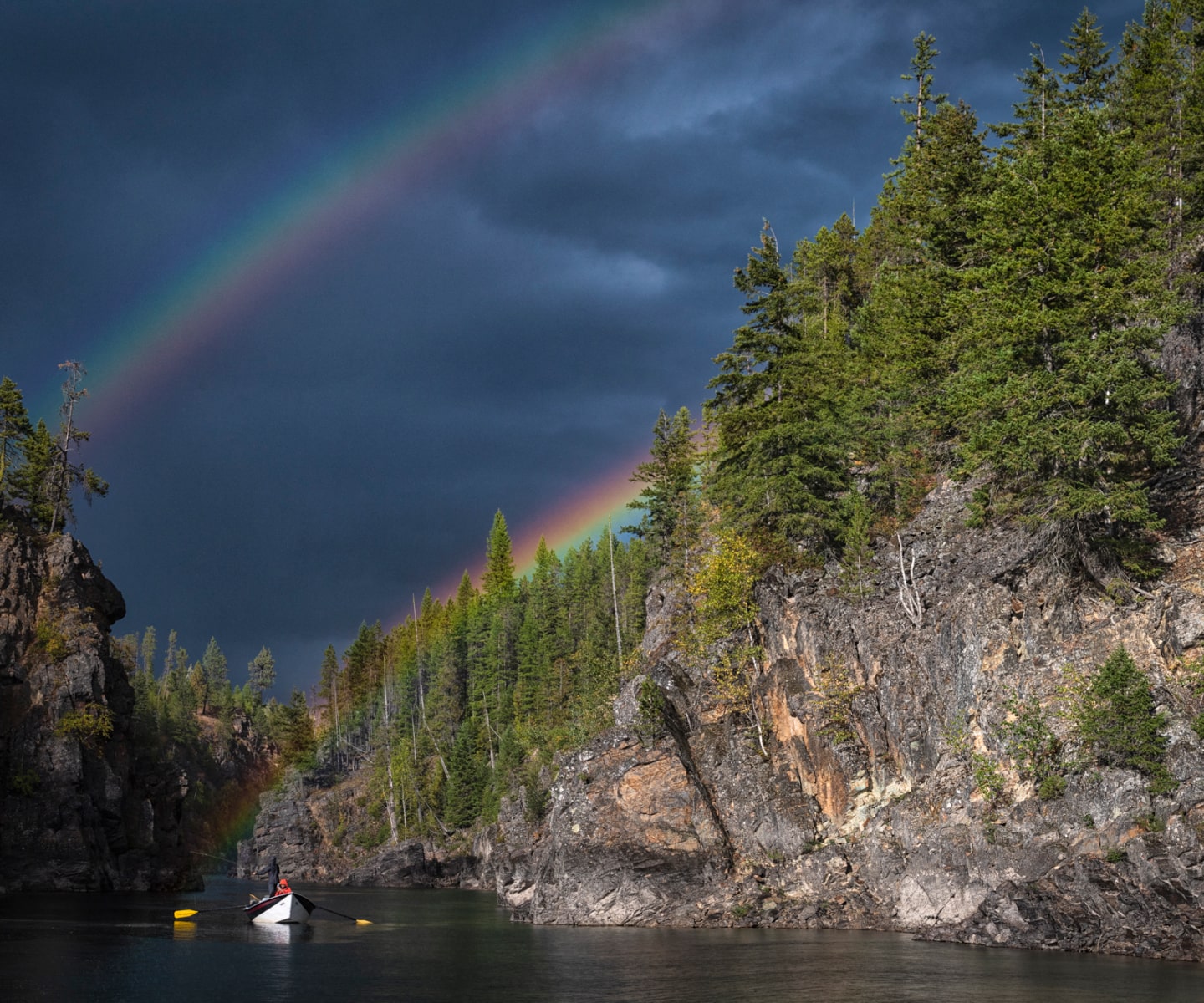 Row boat on the Flathead River with a rainbow in the distance