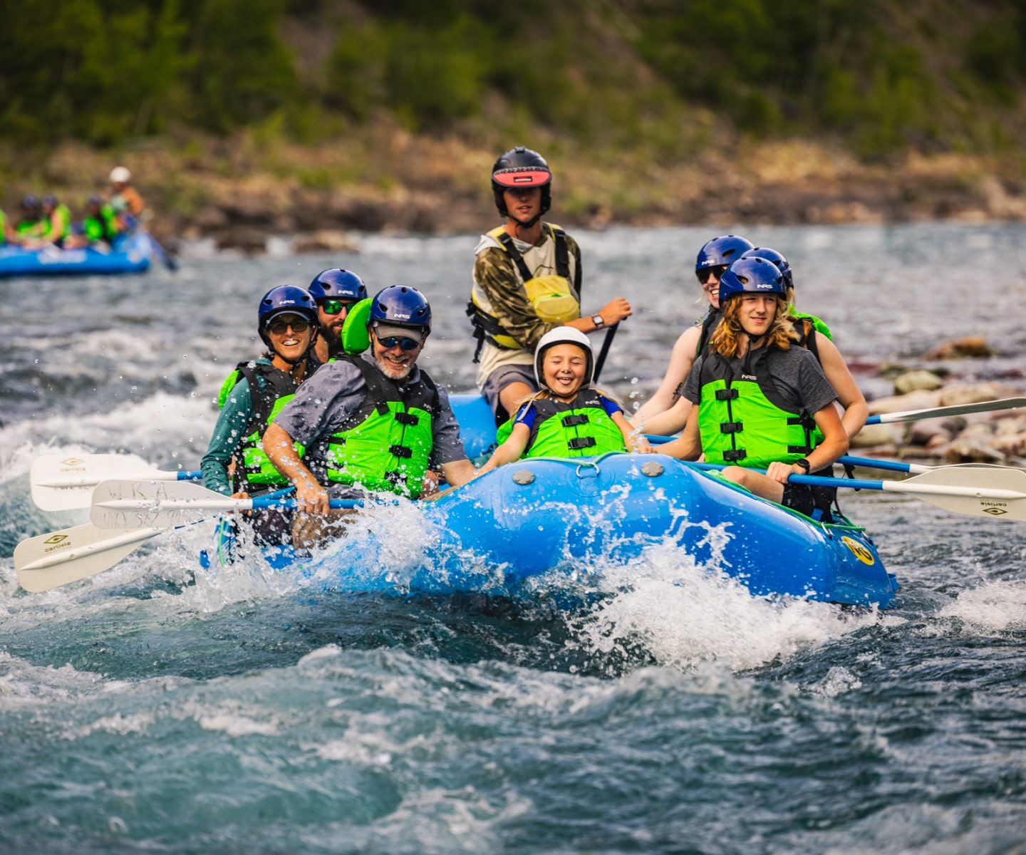 Smiling family enjoying a whitewater rafting trip with Wild River
